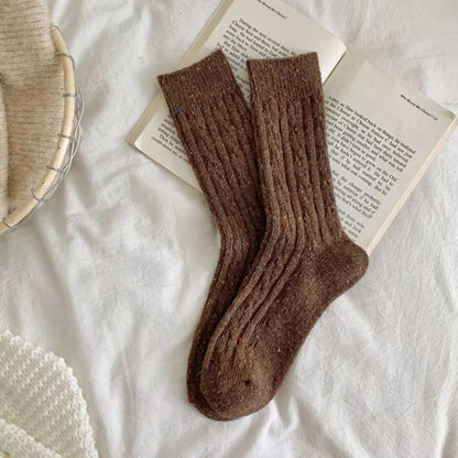 Braune Wollsocken auf offenem Buch, gemütlich, warm, Strickdesign, Herbstmode Accessoire.