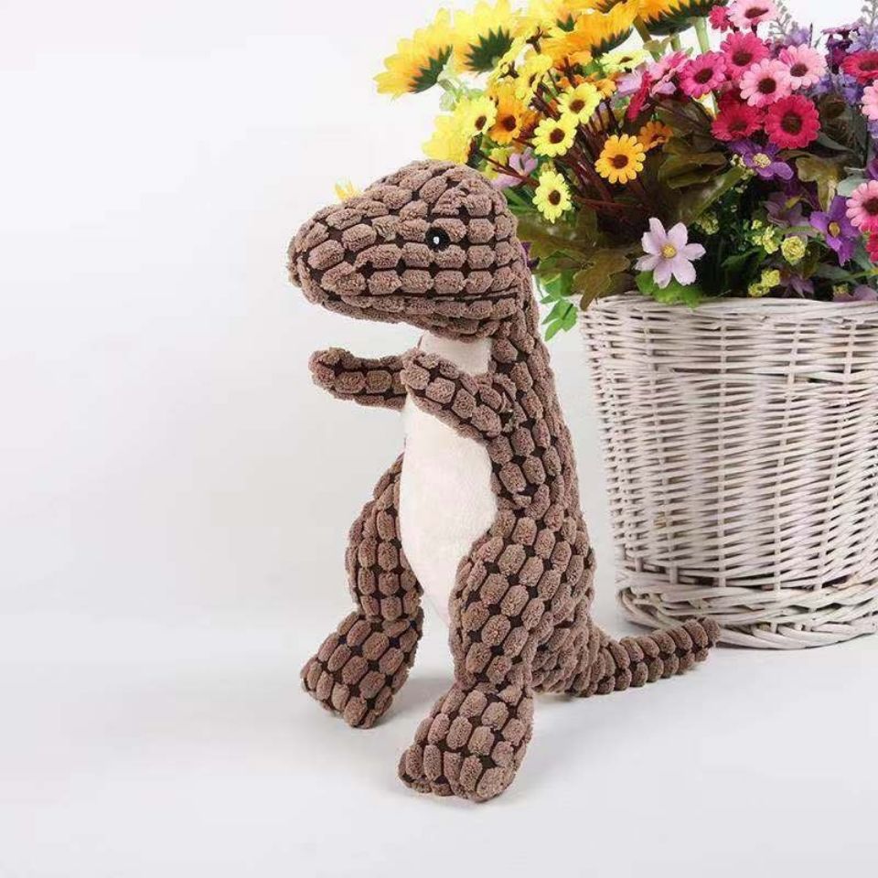 Braunes Dinosaurier-Plüschtier vor Korb mit bunten Blumen, Kinderzimmer-Deko.
