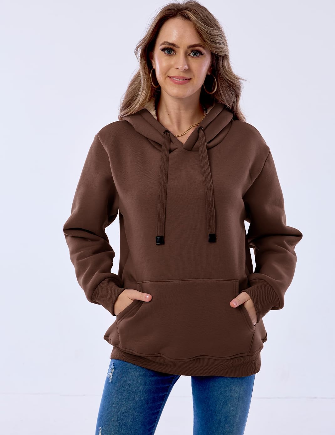 Frau in braunem Kapuzenpullover, Kängurutasche, lässig, modisch, Damenmode, Herbstkleidung.