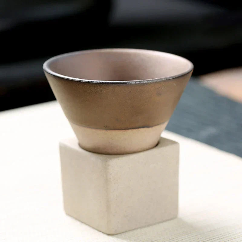 Braune Keramikschale auf weißem Sockel, modernes Design, minimalistische Dekoration.