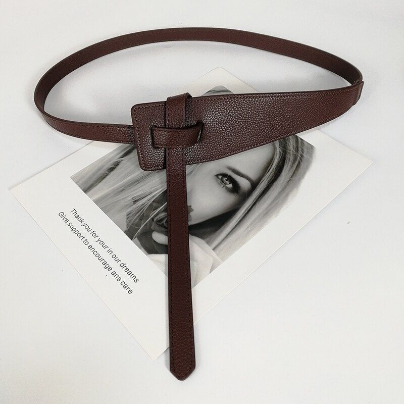 Brauner Ledergürtel mit Knoten-Design auf Schwarz-Weiß-Foto, modisches Accessoire.