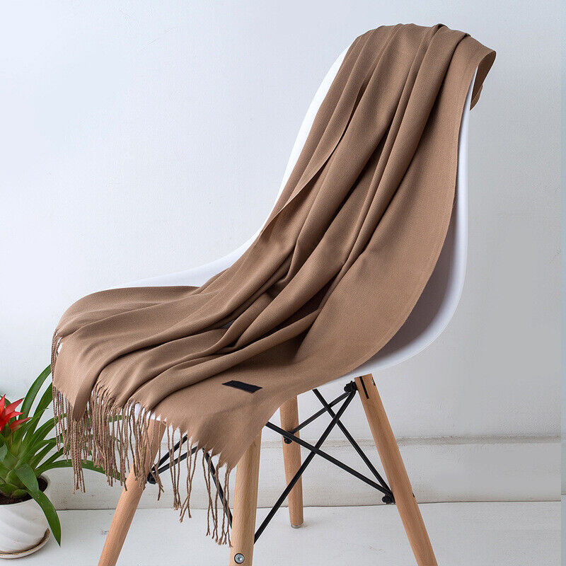 Brauner Kaschmirschal auf weißem Stuhl, weiches Material, modisches Accessoire, Wohnzimmer.