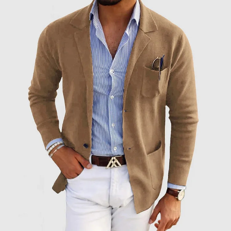 Herren Strickjacke beige, eleganter Stil, kombiniert mit blauem Hemd und weißer Hose.