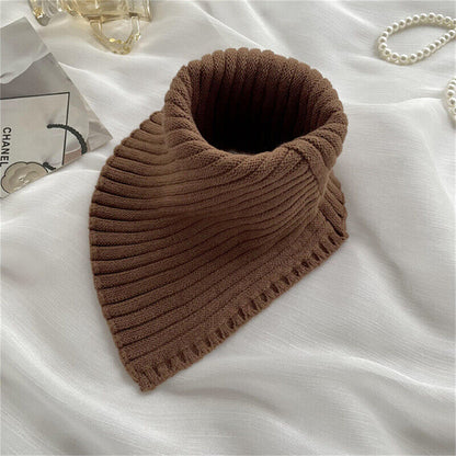 Brauner Strickschal auf weißem Stoff, modisches Accessoire, Herbst-Winter, Damenmode.