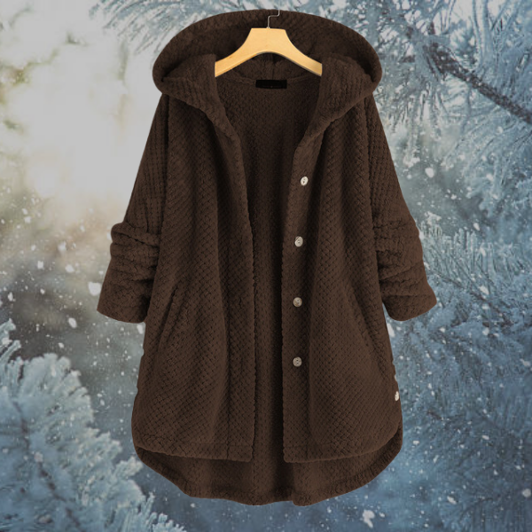 Brauner Damenmantel mit Kapuze, Knöpfen und Taschen, Wintermode, vor verschneitem Hintergrund.