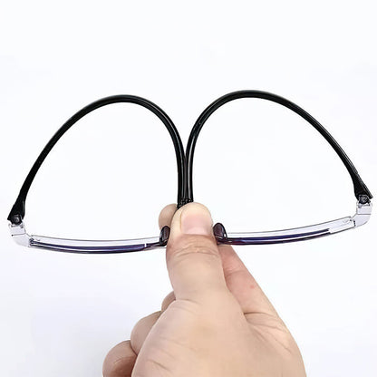 Hand hält schwarze, flexible Lesebrille, faltbar, leicht, ideal für unterwegs.