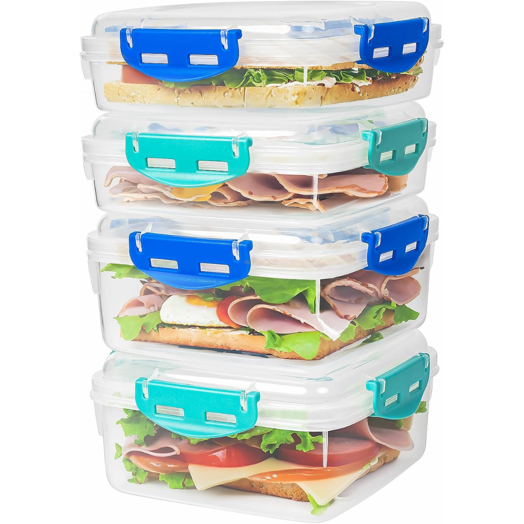 Vier transparente Brotdosen mit blauen Verschlüssen, gefüllt mit Sandwiches.