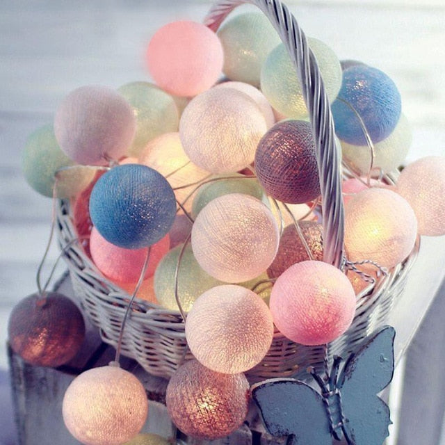 Bunte LED-Lichterkette in Korb, Baumwollkugeln, dekorative Beleuchtung, Pastellfarben.