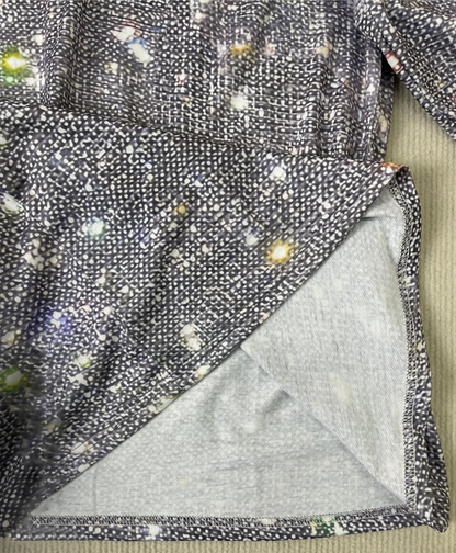 Graues, gepunktetes Damenkleid aus Baumwolle mit buntem Muster, Nahaufnahme des Stoffes.