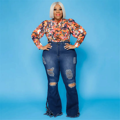 Frau in zerrissener blauer Schlagjeans und buntem Oberteil vor blauem Hintergrund.