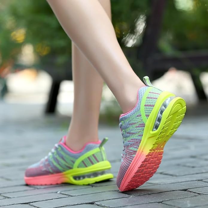 Frau in bunten Laufschuhen mit Neonsohle auf Pflasterweg, sportlich, bequem, modisch.