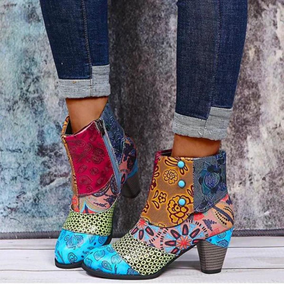 Bunte Damenstiefeletten mit Blumenmuster, Patchwork-Design, Reißverschluss, Absatz, Jeanshintergrund.