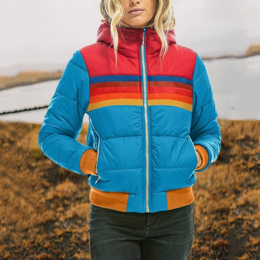 Frau in bunter Daunenjacke, blau mit roten und orange Streifen, Outdoor-Herbstmode.