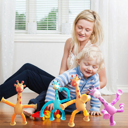 Eine Mutter spielt mit einem Kind auf dem Boden, umgeben von bunten Giraffen-Spielzeugen.