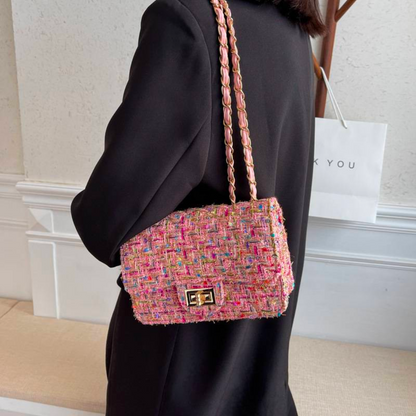 Frau mit rosa Tweed-Handtasche, Kettengurt, elegantes Design, modisches Accessoire.