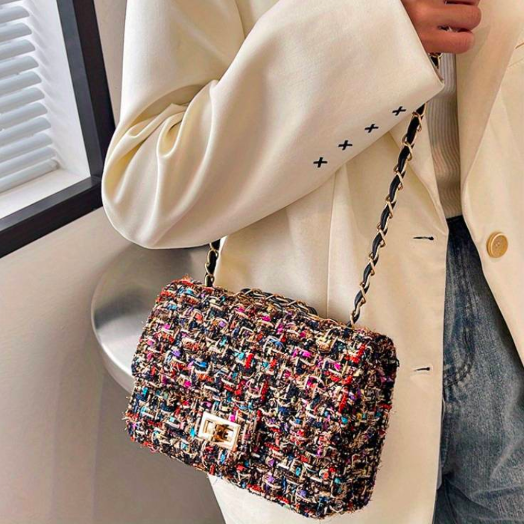 Frau mit bunter Tweed-Handtasche, Kettengurt, elegantes Design, modisches Accessoire.
