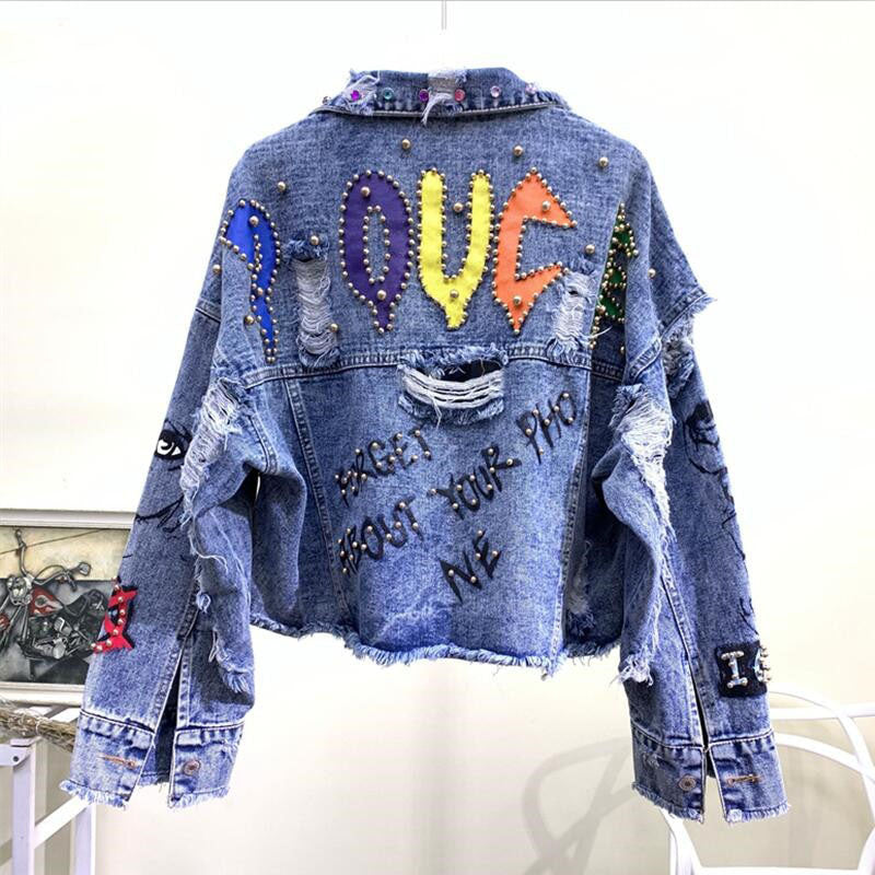 Zerrissene Jeansjacke mit bunten Buchstaben und Nieten, Vintage-Stil, Unisex-Mode.