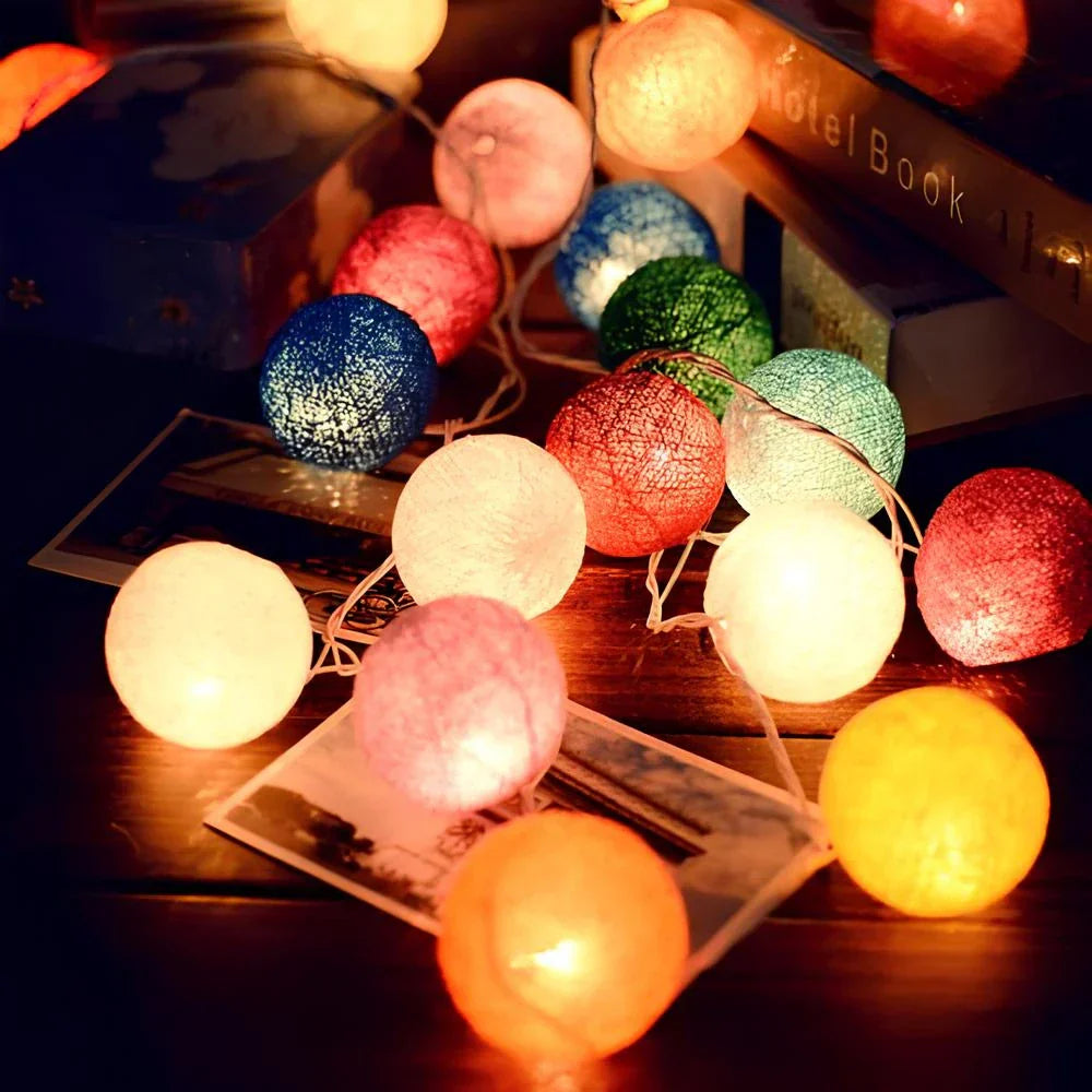 Bunte LED-Lichterkette mit Baumwollkugeln, stimmungsvolle Beleuchtung, Dekoration, Innenbereich.