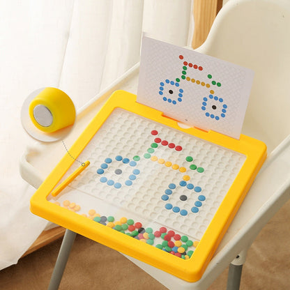 Gelbes magnetisches Mosaikspielzeug für Kinder, mit bunten Kugeln und Vorlage, auf Tisch.