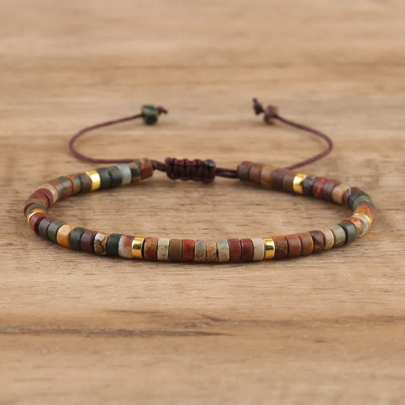 Armband aus Holzperlen, verstellbar, mehrfarbig, handgefertigt, Boho-Stil, auf Holztisch.