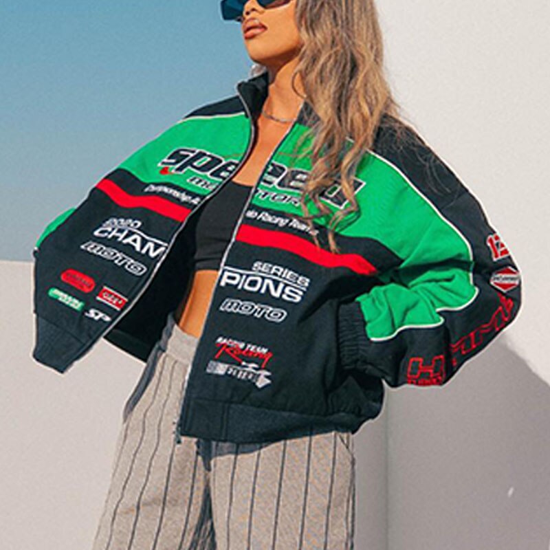 Frau in grüner und schwarzer Rennjacke, gestreifte Hose, Sonnenbrille, modisch, urban.