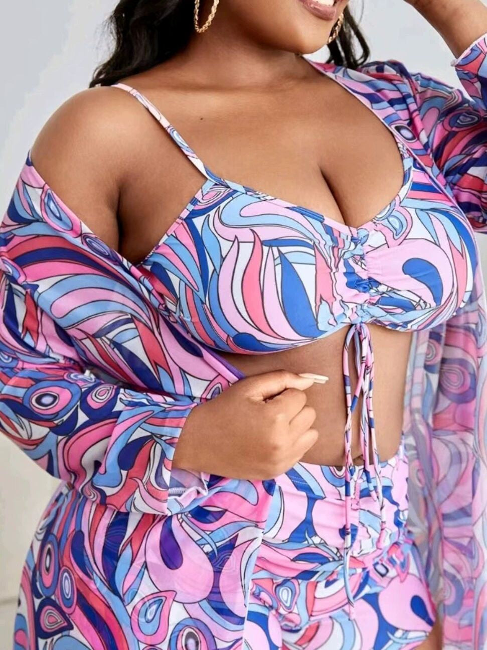 Frau in bunter, gemusterter Strandmode, bestehend aus Top und Rock, in Rosa und Blau.