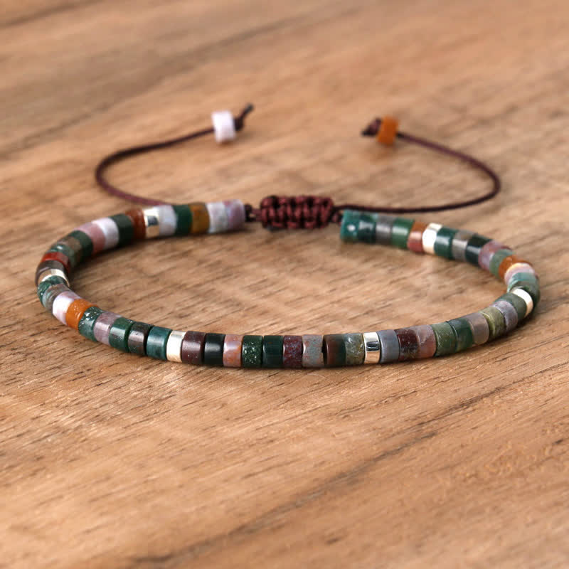 Armband aus bunten Natursteinperlen, verstellbar, handgefertigt, auf Holzoberfläche.