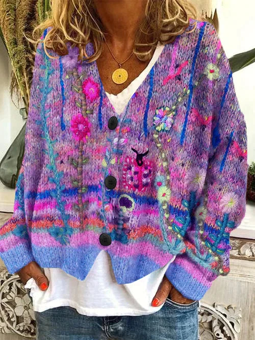 Frau trägt lila Strickjacke mit Blumenmuster, V-Ausschnitt, Knöpfen, lässiger Stil.