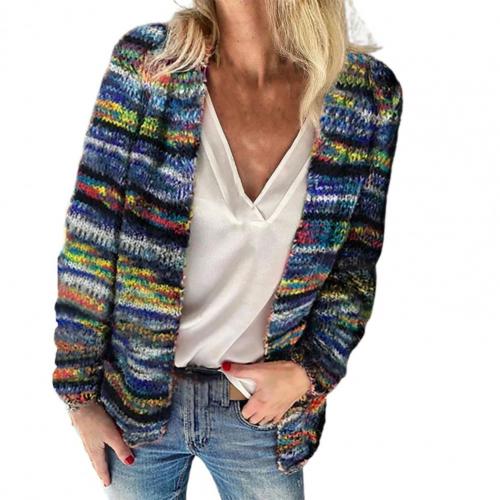 Frau in bunter Strickjacke, weißem V-Ausschnitt-Top und blauer Jeans, modischer Freizeitlook.