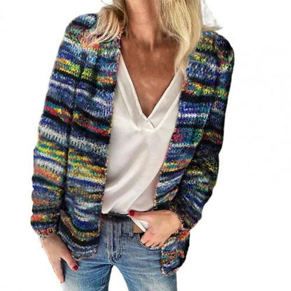 Frau in bunter Strickjacke, weißem V-Ausschnitt-Top und blauer Jeans, modischer Freizeitlook.