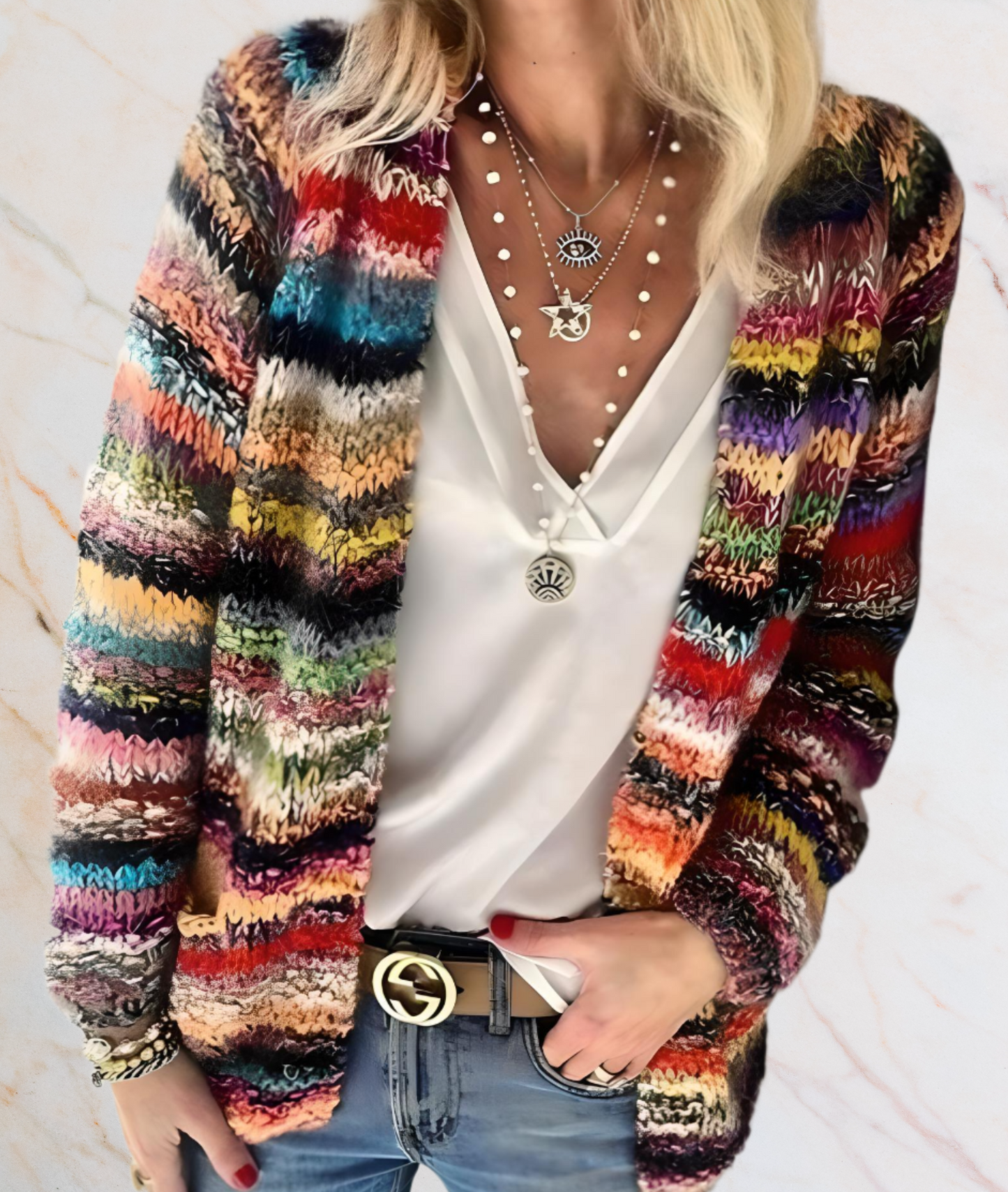 Frau mit buntem Strickcardigan, weißer Bluse, Jeans und Schmuck, modisch, lässig.