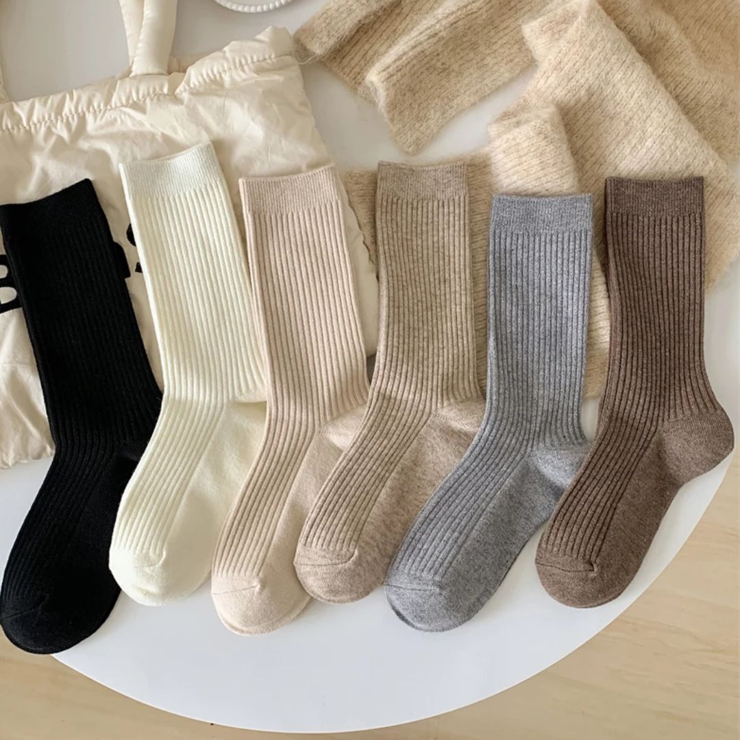 Sechs Paar gerippte Socken in verschiedenen Farben auf einem Tisch, Baumwolle, bequem, modisch.