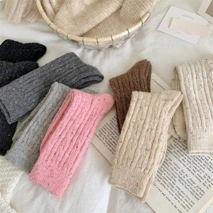 Bunte Stricksocken aus Wolle, verschiedene Farben, auf weißem Hintergrund, gemütliche Wintermode.