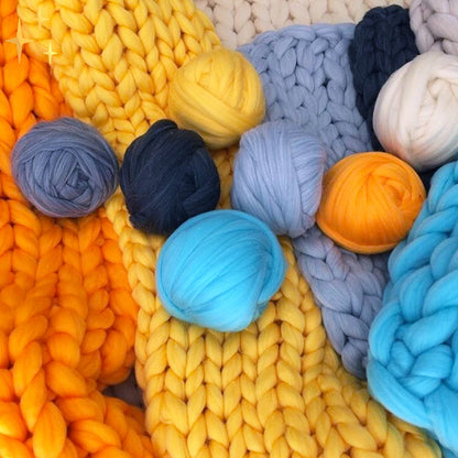 Bunte Wollknäuel und Strickdecken, gelb, blau, grau, aus dicker Merinowolle, Handarbeit.