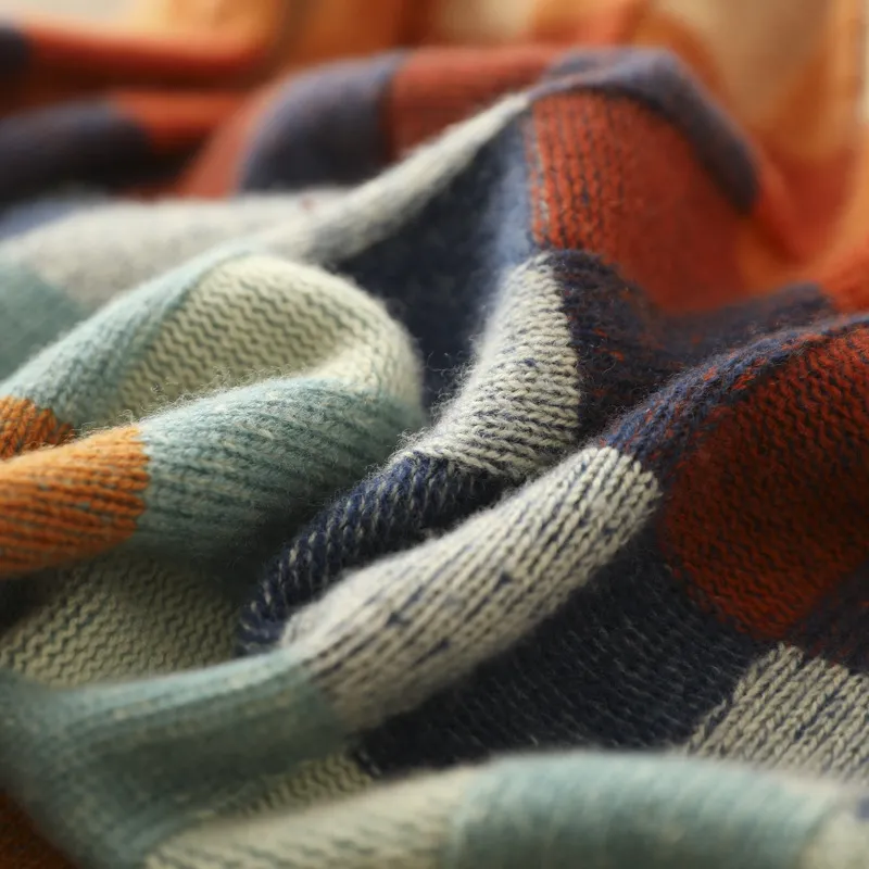 Bunte gestrickte Decke aus Wolle, kariertes Muster, weiche Textur, gemütlich und warm.