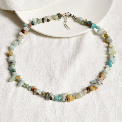 Halskette aus bunten Edelsteinen, handgefertigt, auf weißem Hintergrund, Schmuck für Damen.