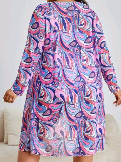 Frau in buntem, langärmligem Kleid mit abstraktem Muster, lila und rosa Farbtöne.