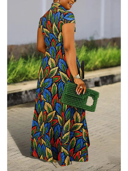 Frau im bunten Maxikleid mit Blattmuster, grüner Handtasche, Sommermode, Straße.