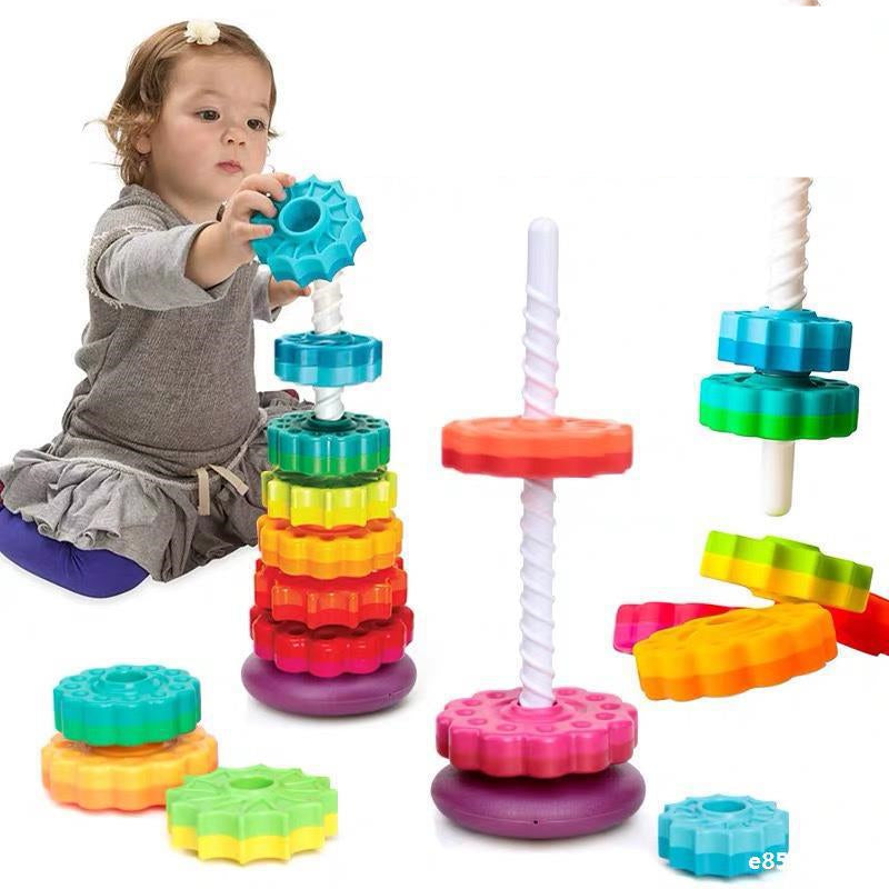 Kleinkind spielt mit buntem Stapelspielzeug aus Kunststoff, Montessori, motorische Fähigkeiten.