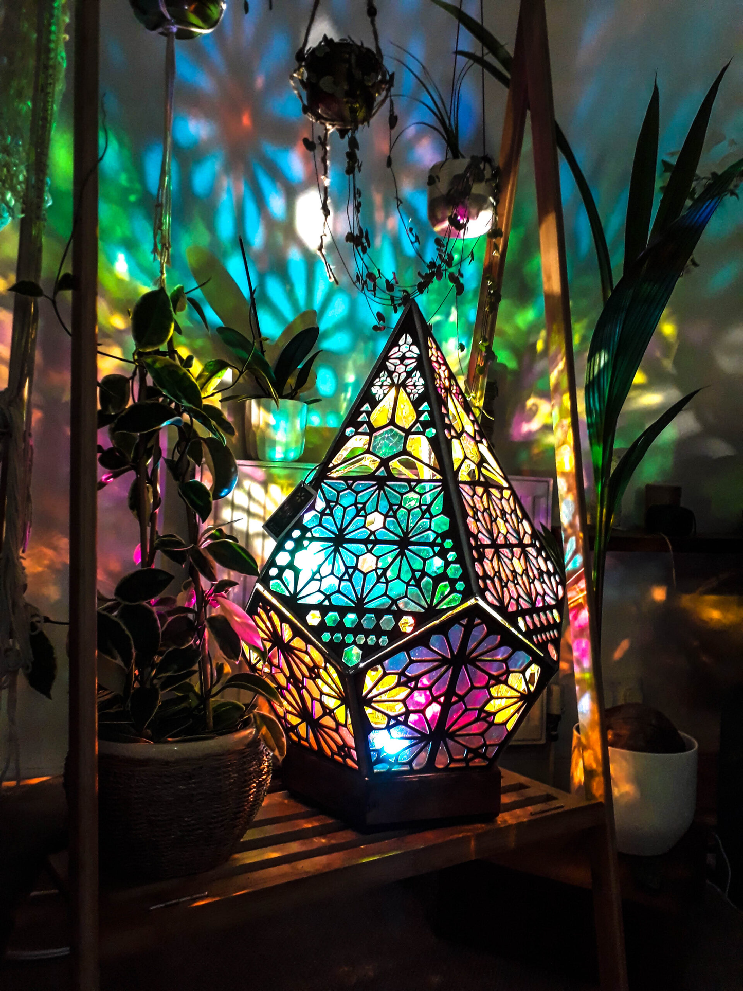 Buntes geometrisches Nachtlicht, Holzrahmen, projiziert farbenfrohe Muster, dekorative Beleuchtung.