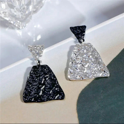 Zweifarbige geometrische Ohrringe, schwarz und silber, modern, strukturiert, modisch.