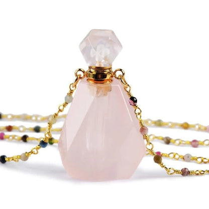 Rosenquarz Parfümflakon mit goldener Kette, facettiert, edelsteinbesetzt, luxuriöses Design.