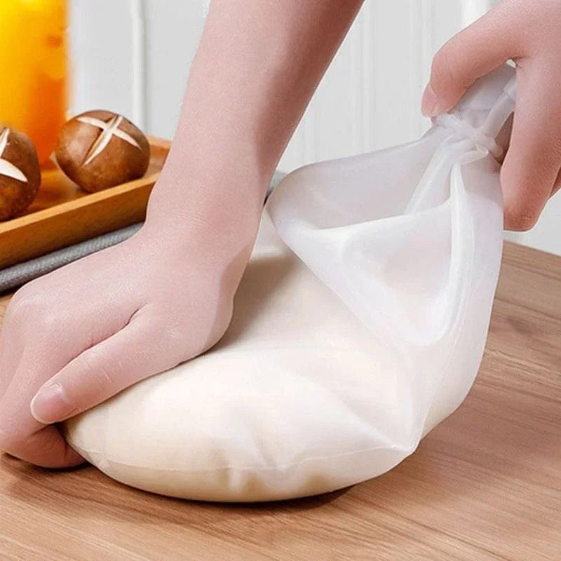 Hand knetet Teig in wiederverwendbarem Silikonbeutel auf Holzoberfläche, Küche, Backzubehör.