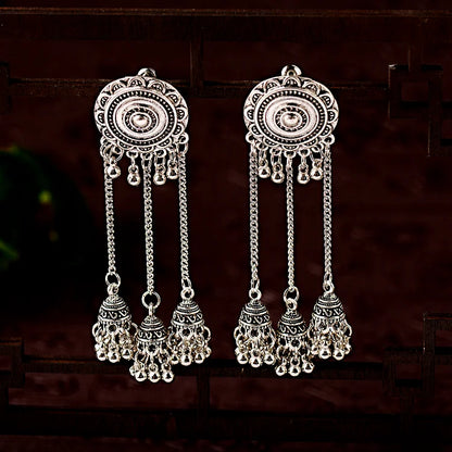 Silberne, lange, indische Ohrringe mit filigranen Details und hängenden Anhängern.