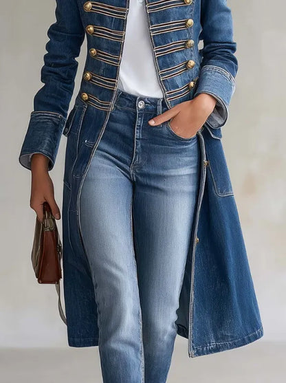 Detalj av kappans nedre del och fickor, buren över jeans, med guldknappar upptill och brun väska i handen. 6