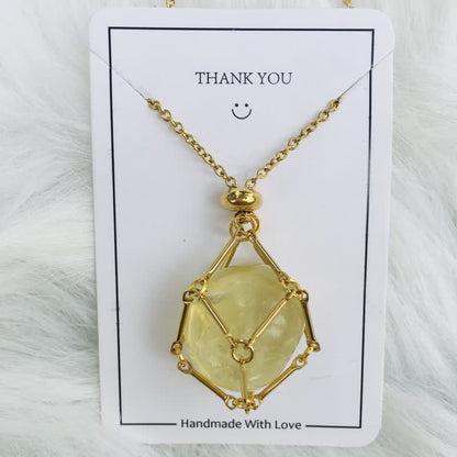 Goldene Halskette mit gelbem Edelsteinanhänger, handgefertigt, auf weißem Hintergrund.