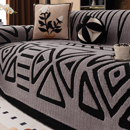 Soffa med grått överdrag och svart geometriskt mönster av trianglar och romber, med blomkudde 15