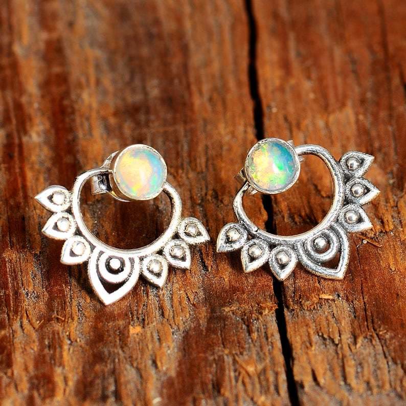 Silberne Ohrringe mit Opal, Boho-Stil, handgefertigt, Vintage-Design, Holz-Hintergrund.