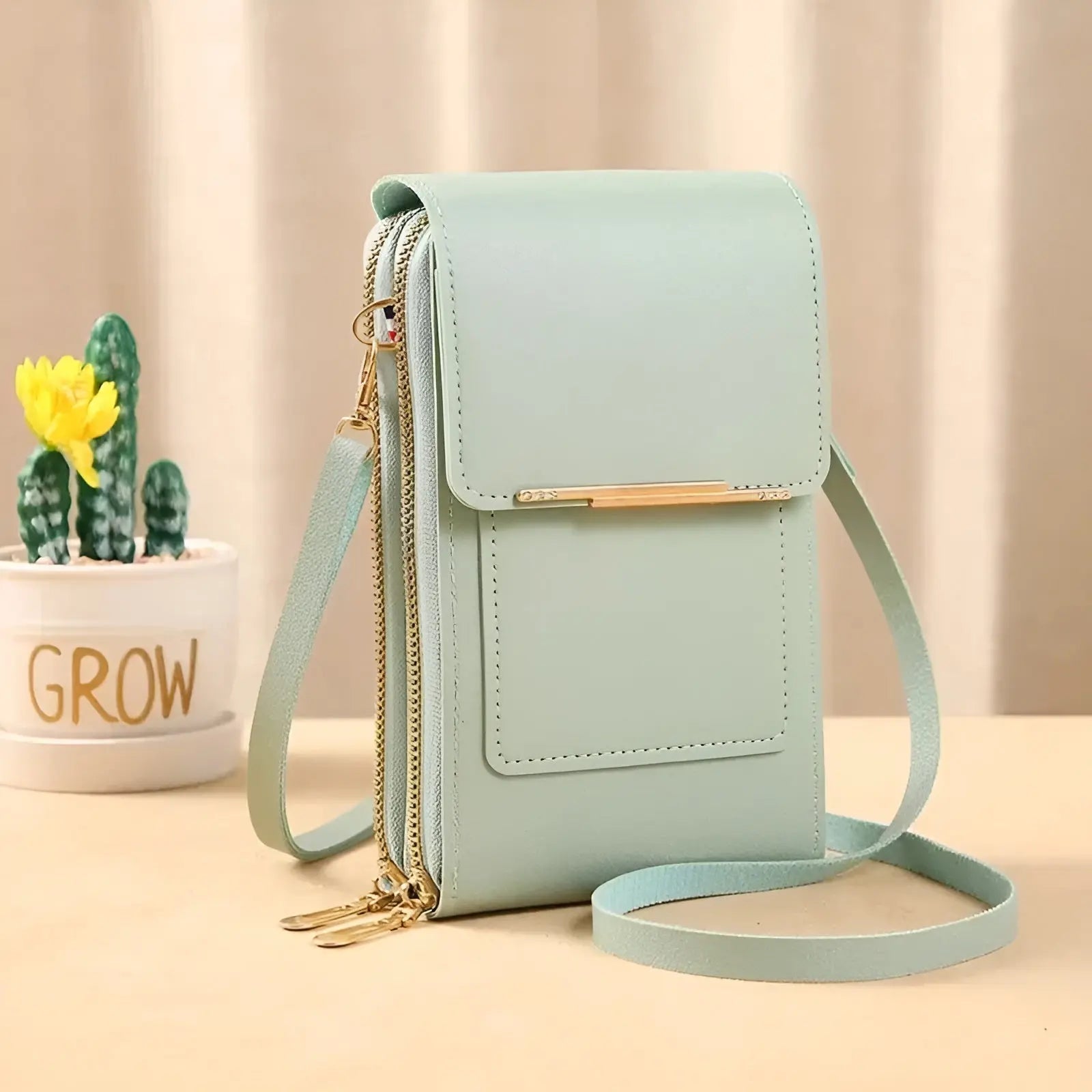 Mintgrüne Umhängetasche aus Leder mit Reißverschluss, ideal für Damenmode und Accessoires.