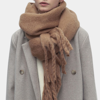 Frau mit beigem Wollschal und grauem Mantel, modisches Winteroutfit, warme Accessoires.